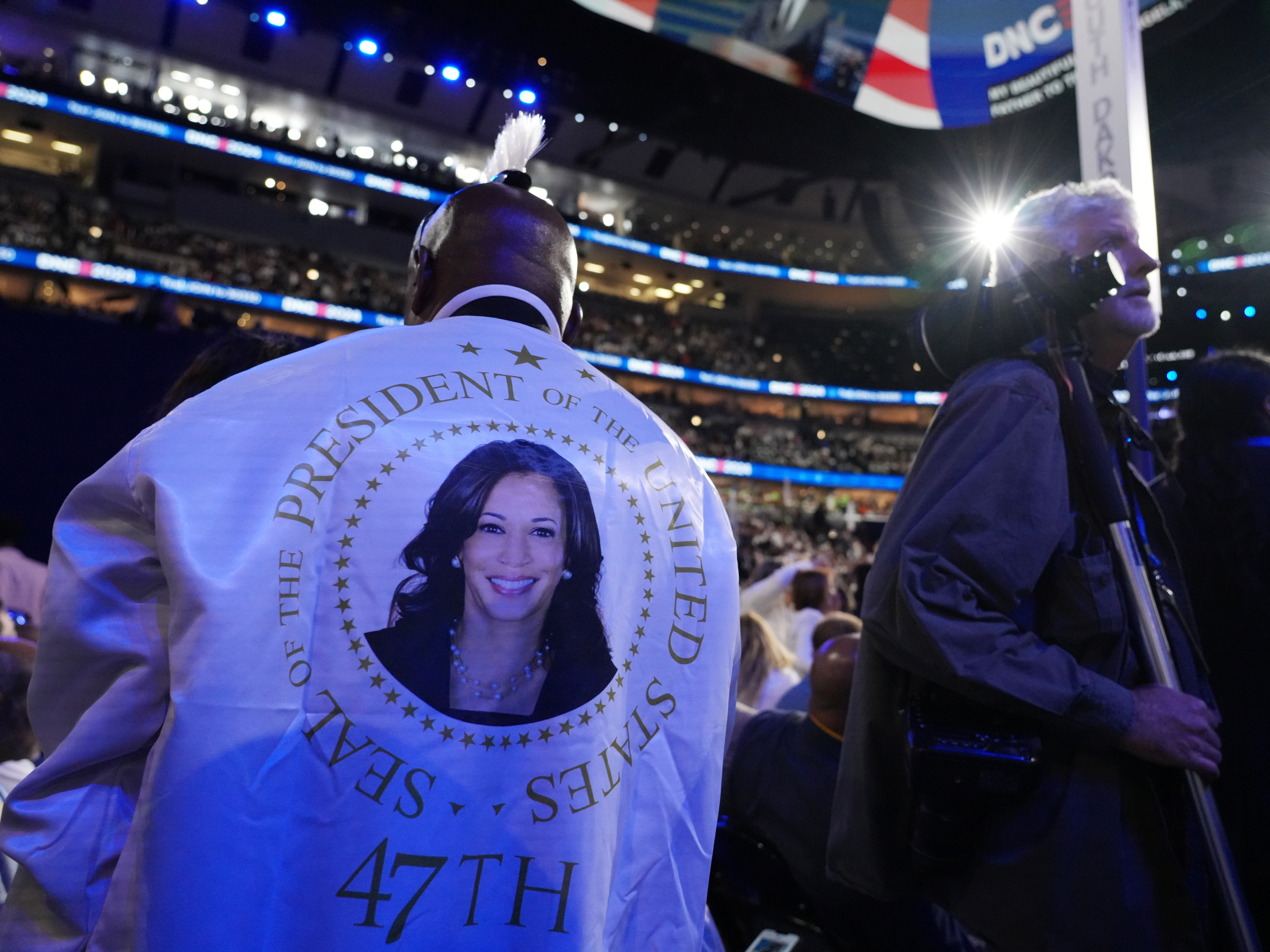 caption: Delegates and journalists roam the floor of the United Center on the final day of the DNC.