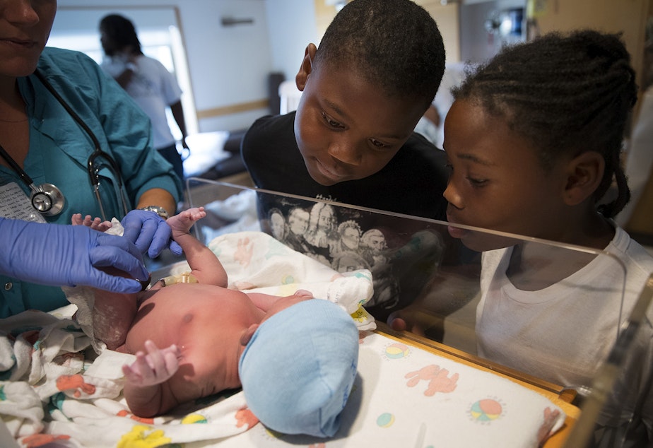 caption: Matthew Hicks, 9, and Mariah Hicks, 7, look at their new brother, Elijah Dayshawn Lindley, as he is placed under a warming lamp on Tuesday, August 29, 2017, at Swedish First Hill Birthing Center in Seattle. 