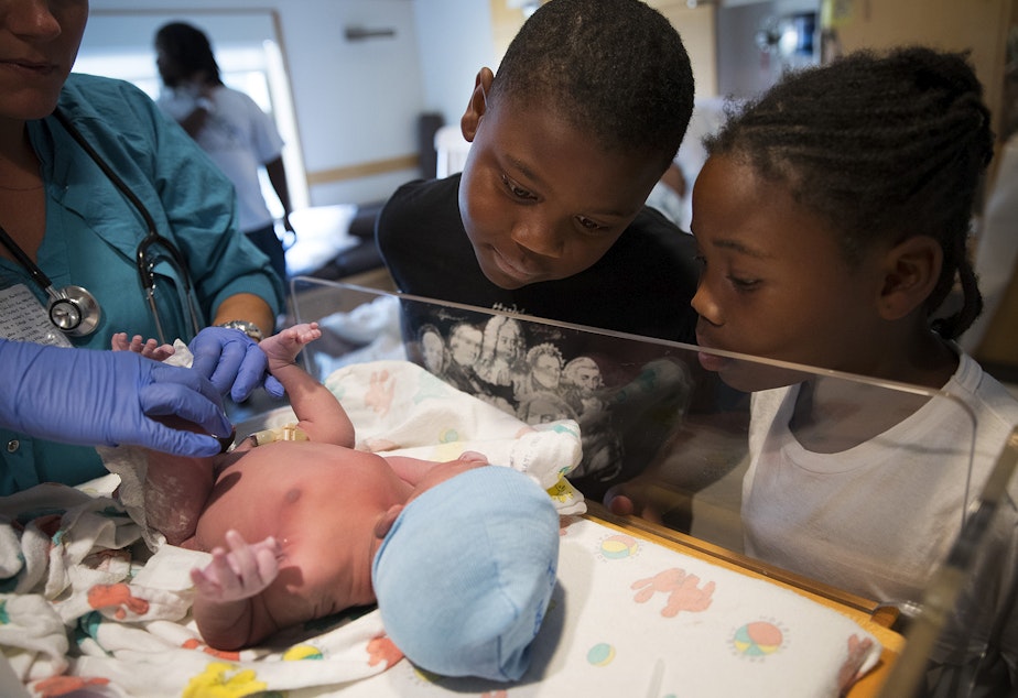 caption: Matthew Hicks, 9, and Mariah Hicks, 7, look at their new brother, Elijah Dayshawn Lindley, as he is placed under a warming lamp on Tuesday, August 29, 2017, at Swedish First Hill Birthing Center in Seattle.