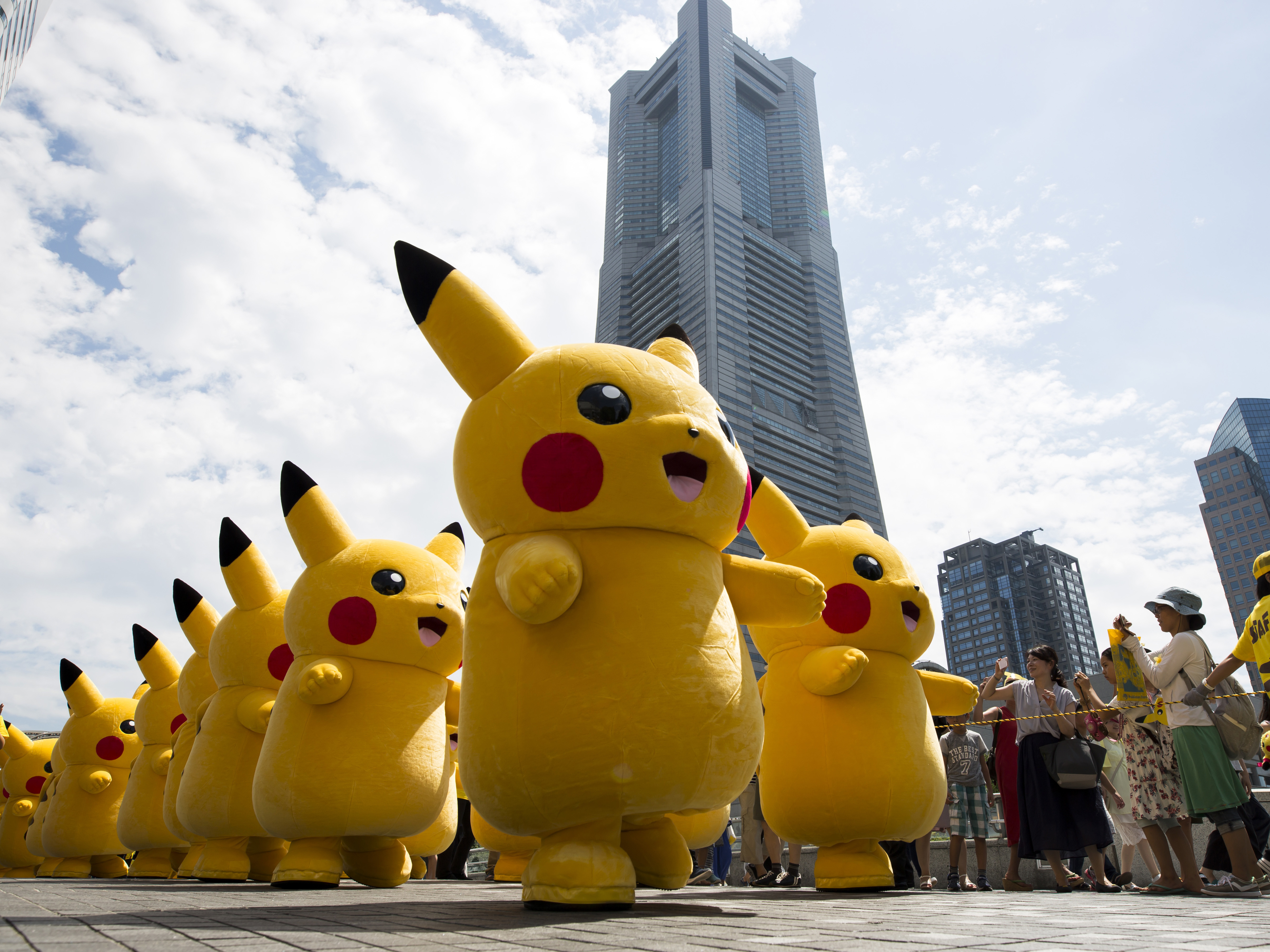 caption: Performers dressed as Pikachu, a character from Pokemon series, march during the Pikachu Outbreak event hosted by The Pokemon Co. on August 9, 2017 in Yokohama, Kanagawa, Japan.