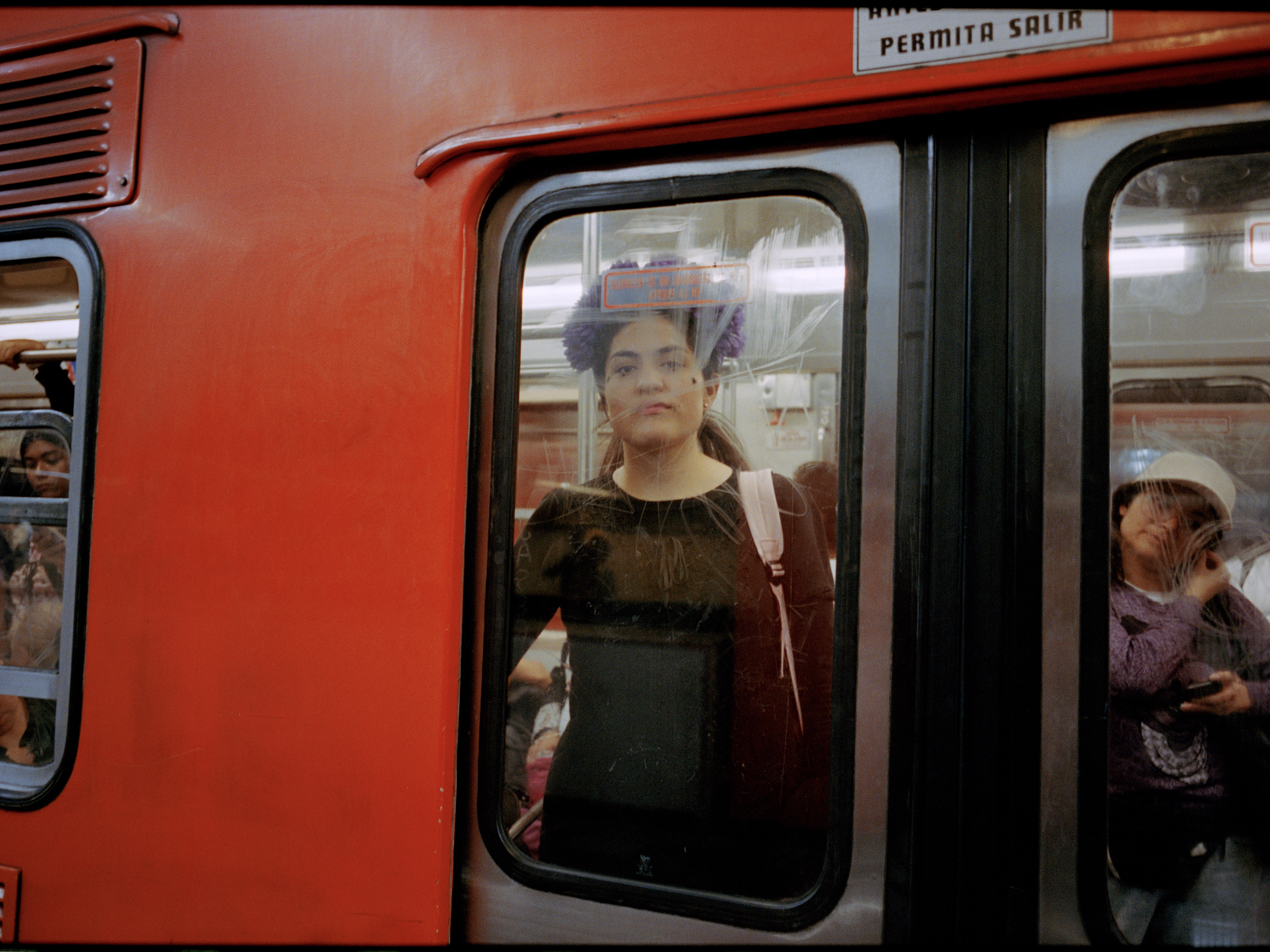 caption: A woman in the window of a women-only metro car in Mexico City on October 2023.