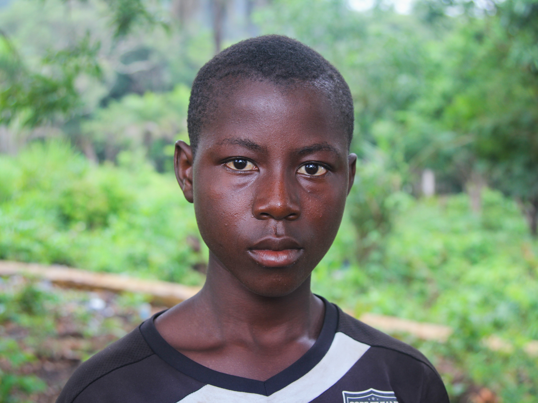 caption: Sahr Tarawaly, 14, works several jobs to earn money to support his mom and two siblings. "I used to like mathematics," the round-faced teenager says. "Now I go down to the beach to fish, to have fish to eat."