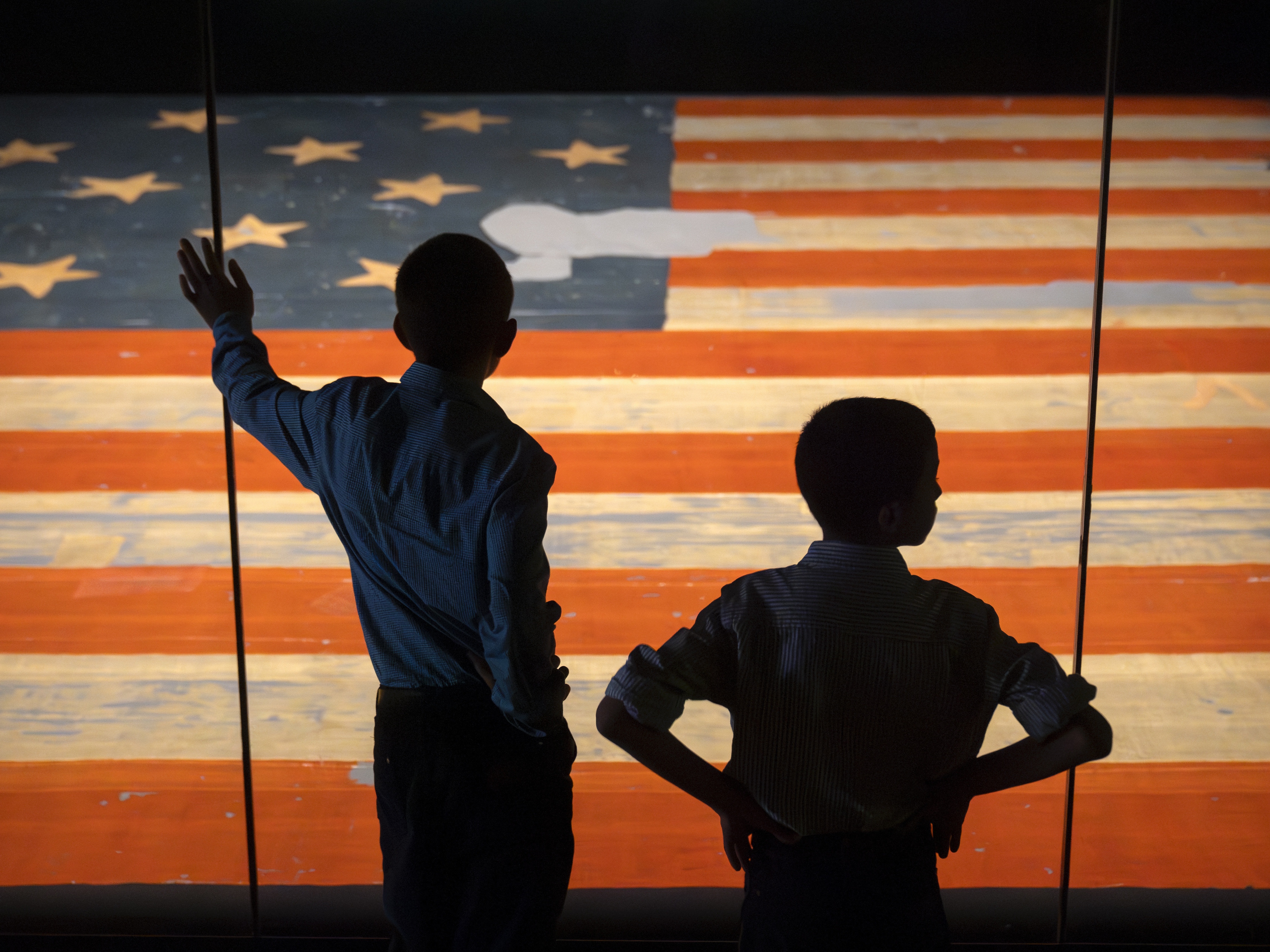 caption: Children look at the Star Spangled Banner, the flag that inspired the lyrics of the American national anthem, at the Smithsonian's National Museum of American History in June in Washington, D.C.