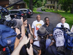 caption: Bill Cosby (center left) and spokesperson Andrew Wyatt (center right) approach members of the media gathered outside Cosby's home in Elkins Park, Pa., on Wednesday after the comedian was released from prison.