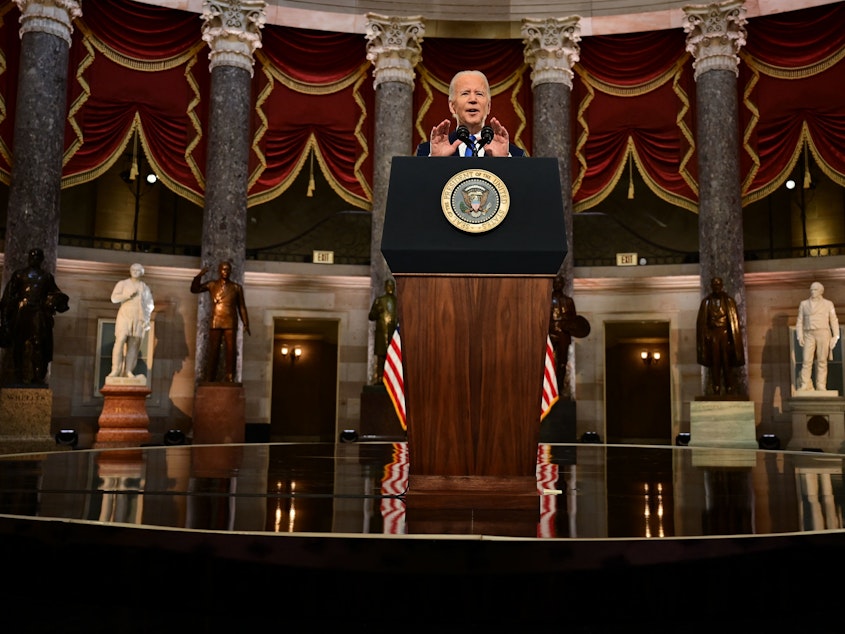 caption: Speaking in Statuary Hall of the Capitol, President Biden described Donald Trump as "not just a former president" but "a defeated former president."