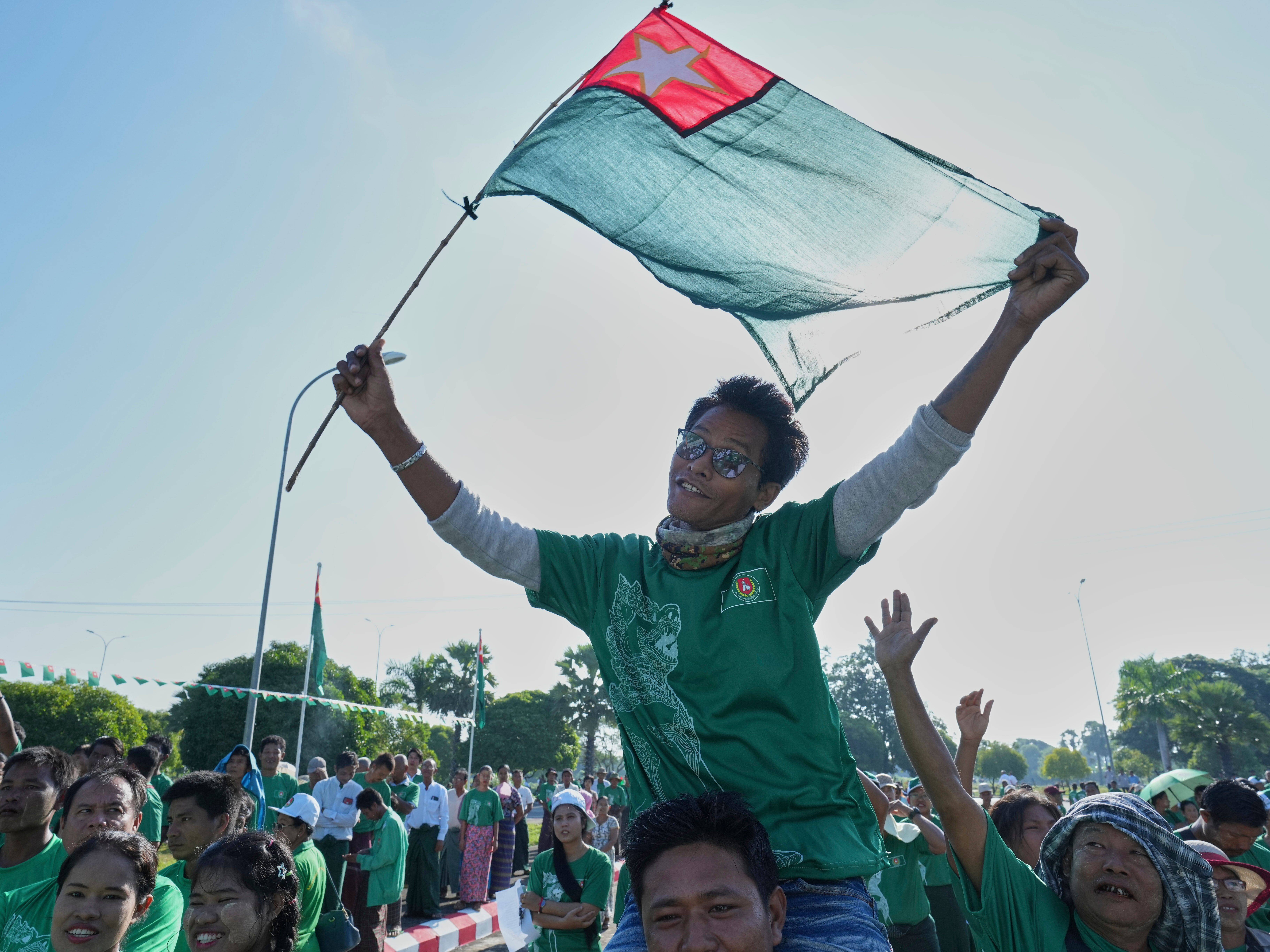 caption: Supporters of the military-backed Union Solidarity and Development Party wave the party flags during the first day of campaigning for the general election, in Naypyitaw, Myanmar, Oct. 28.