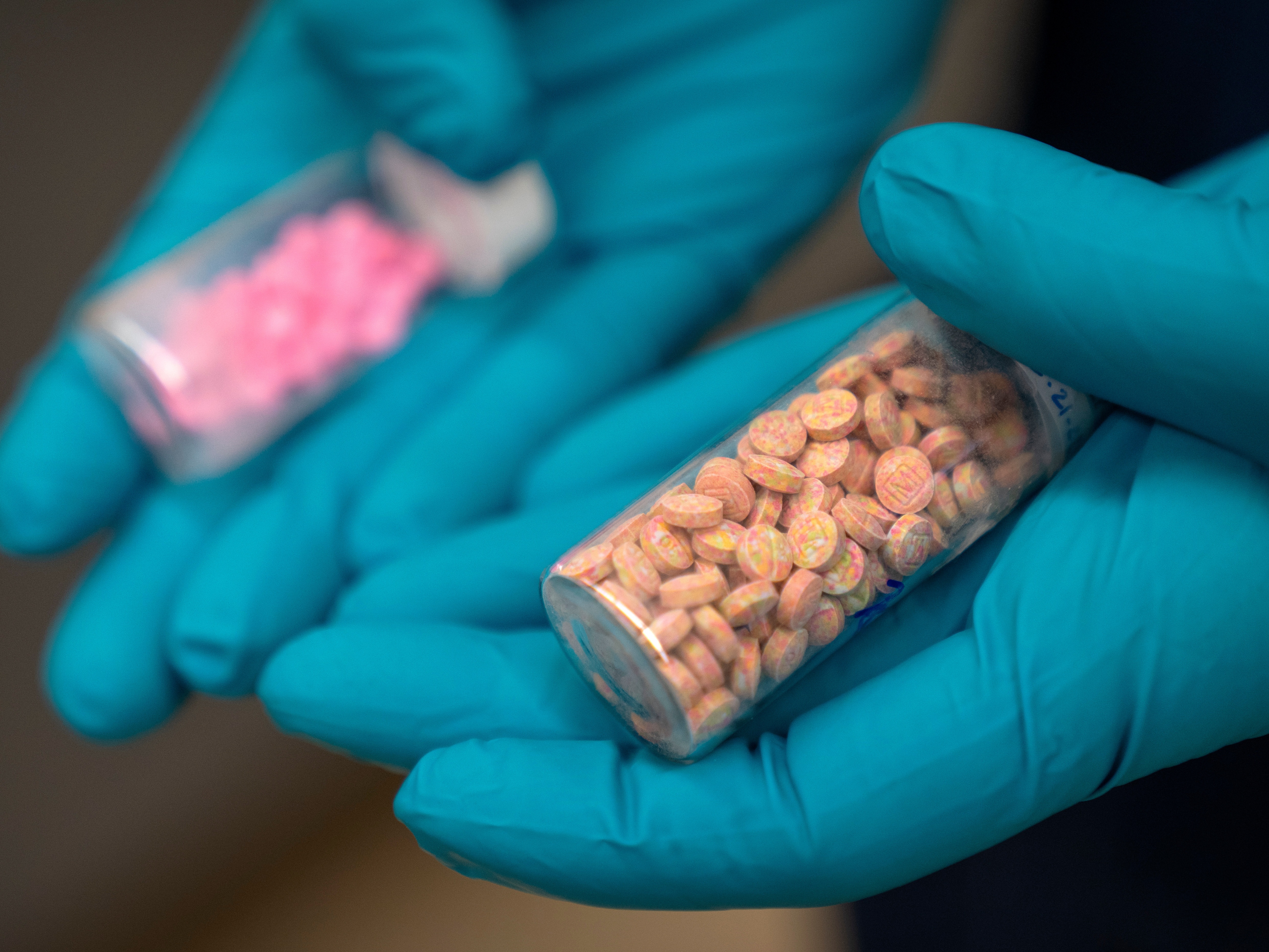 caption: A forensic chemist with the Drug Enforcement Administration holds vials of fentanyl pills at a DEA research laboratory in this file photo. Fentanyl deaths are plunging in the U.S, but the recovery is threatened by a new "synthetic soup" of toxic street drugs.