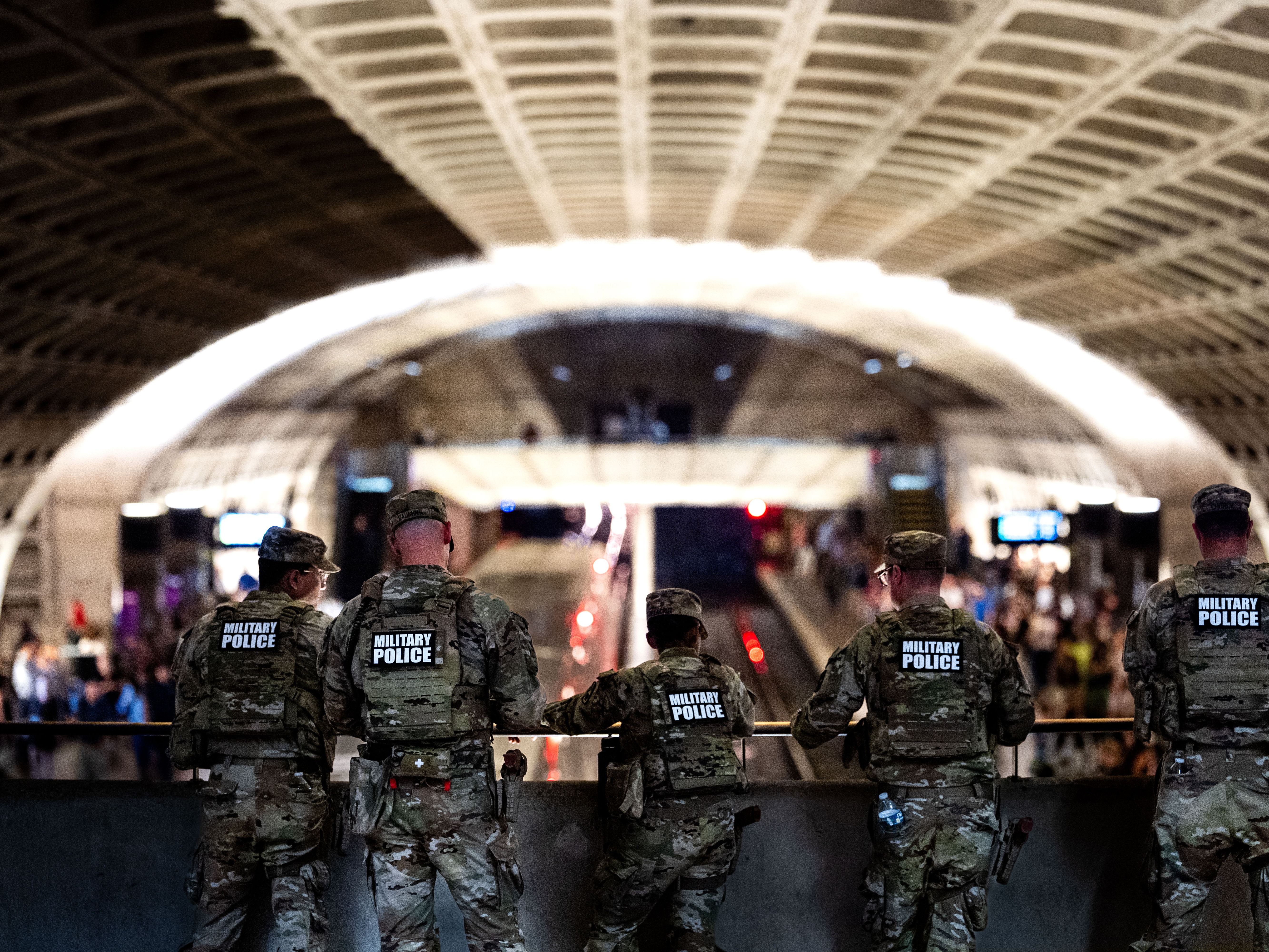 caption: National Guard Military Police watch as trains arrive and depart during rush hour at L'Enfant Plaza station on Sept. 4 in Washington, D.C.