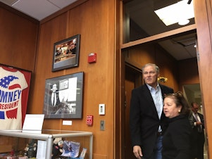 caption: Gov. Jay Inslee enters a conference room at the New Hampshire Institute of Politics at Saint Anselm College where he spoke to students last month.