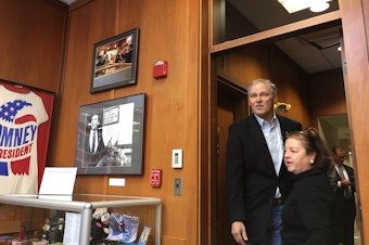 caption: Gov. Jay Inslee enters a conference room at the New Hampshire Institute of Politics at Saint Anselm College where he spoke to students last month.