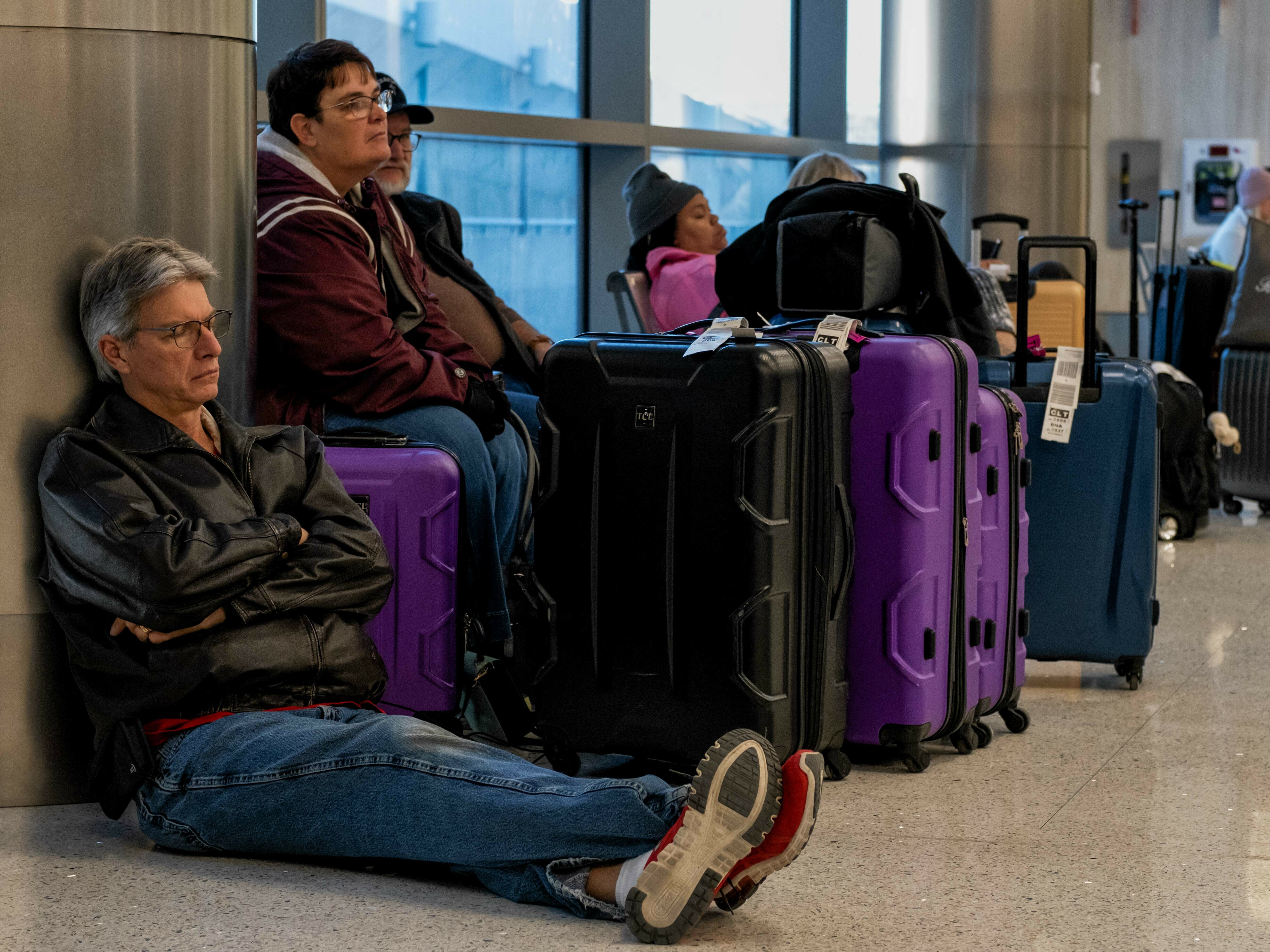 caption: Travelers wait next to their luggage near the Southwest Airlines baggage claim area at the Nashville International Airport after the airline canceled thousands of flights in Nashville, Tenn., on Tuesday.