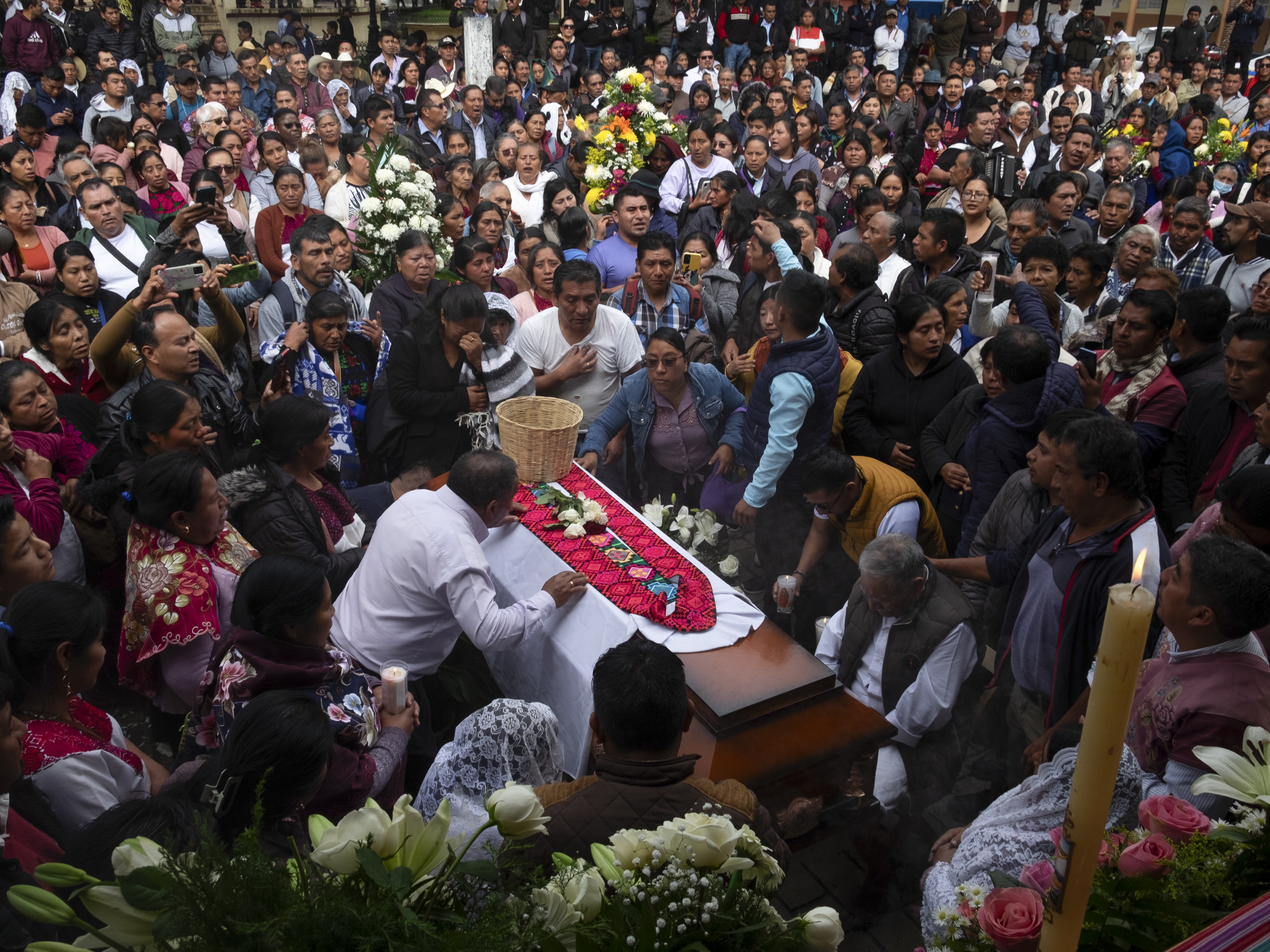 caption: People gather around the coffin of slain Catholic priest and activist Marcelo Pérez during a mass at the main plaza in San Andrés Larráinzar, Chiapas state, Mexico, on Monday.