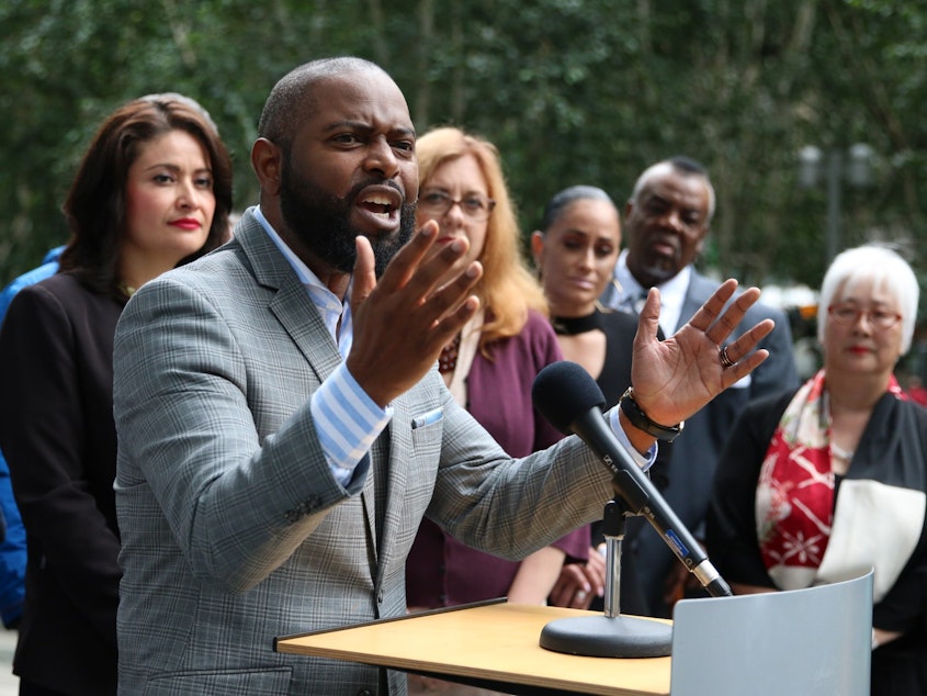 caption: Andre Taylor, of the community group Not This Time, speaks at a press conference on July 15, 2019.