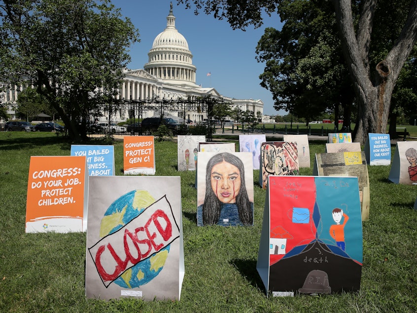 caption: An installation of children's art is set up outside the Capitol on Wednesday. Kids can develop "severe" symptoms from the coronavirus, the Centers for Disease Control and Prevention said in a report released Friday.
