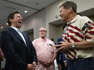 caption: Florida Gov. Ron DeSantis (L) speaks with attendees during an Iowa GOP reception on May 13, 2023 in Cedar Rapids, Iowa.