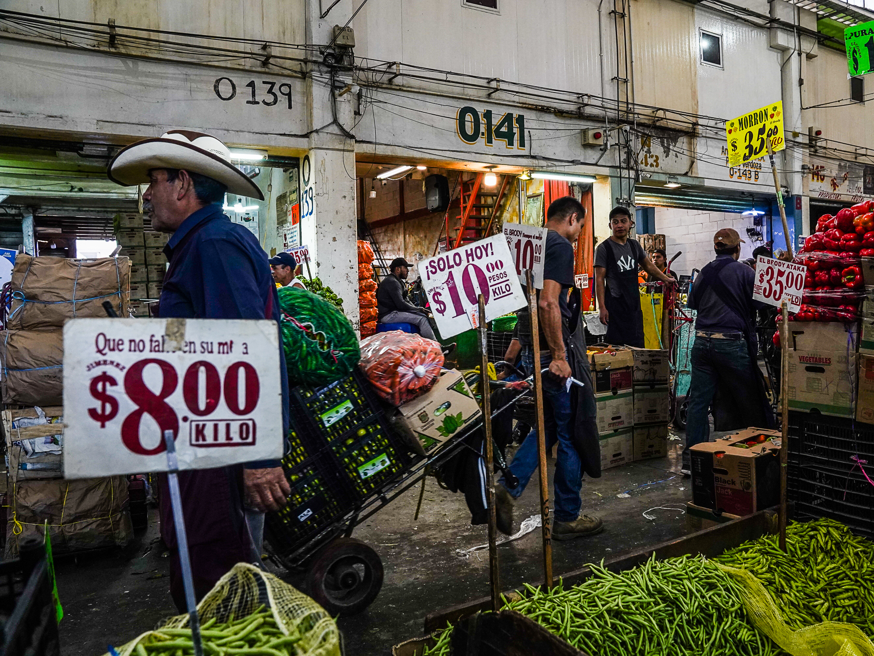 caption: Every day, 19,000 workers ferry produce around the Central de Abastos on dollies and wheelbarrows.