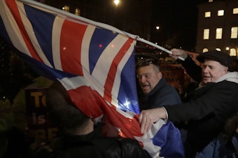caption: Brexit supporters and opponents shout at each other outside Parliament in London on Thursday, the day that British lawmakers voted to delay Brexit.