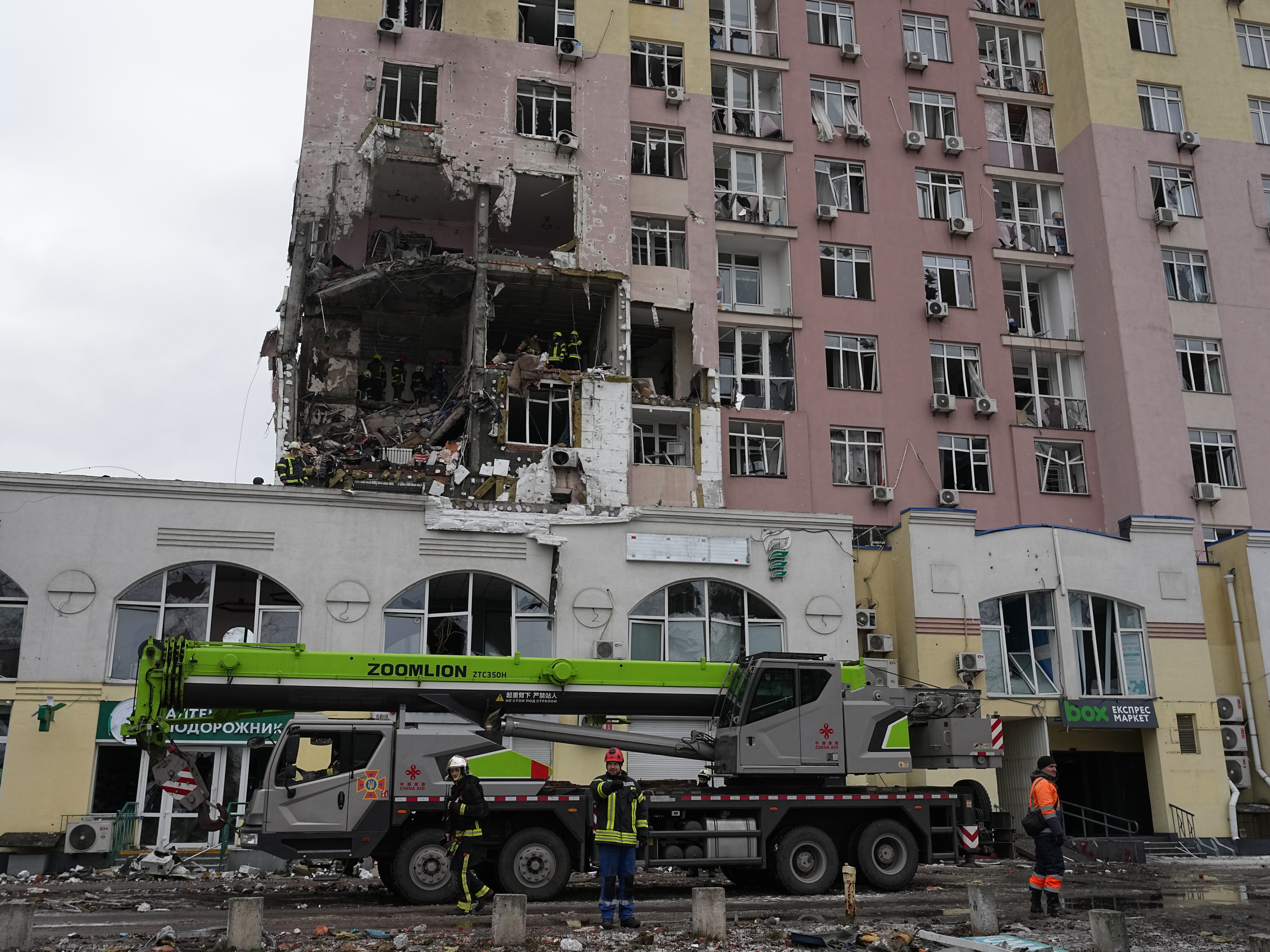 caption: Rescuers work on the scene of a building damaged by a Russian attack in Kyiv, Ukraine, Saturday, Dec. 27, 2025.
