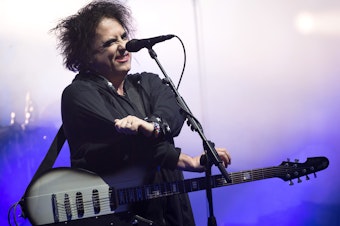caption: Robert Smith of The Cure performs in Glastonbury, England, in 2019. This week, he shared his frustrations with Ticketmaster, and announced Thursday that the company would lower fees and offer partial refunds to The Cure's ticket purchasers.
