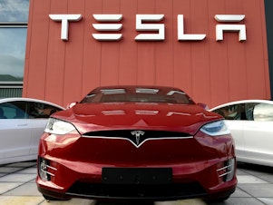 caption: A Tesla car is displayed at a showroom and service center for the auto maker in Amsterdam on Oct. 23, 2019. Tesla recently cut prices across the board, a move with big potential ramifications for the automaker as well as for the industry.