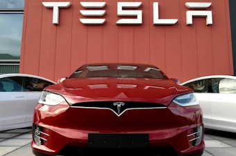 caption: A Tesla car is displayed at a showroom and service center for the auto maker in Amsterdam on Oct. 23, 2019. Tesla recently cut prices across the board, a move with big potential ramifications for the automaker as well as for the industry.