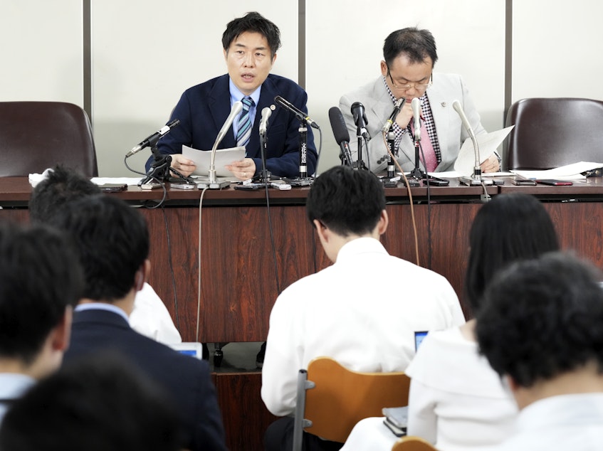 caption: The unnamed plaintiff's lawyers, Kazuyuki Minami, left, and Masafumi Yoshida, right, speak to media after the ruling of the Supreme Court on Wednesday in Tokyo.