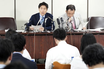 caption: The unnamed plaintiff's lawyers, Kazuyuki Minami, left, and Masafumi Yoshida, right, speak to media after the ruling of the Supreme Court on Wednesday in Tokyo.