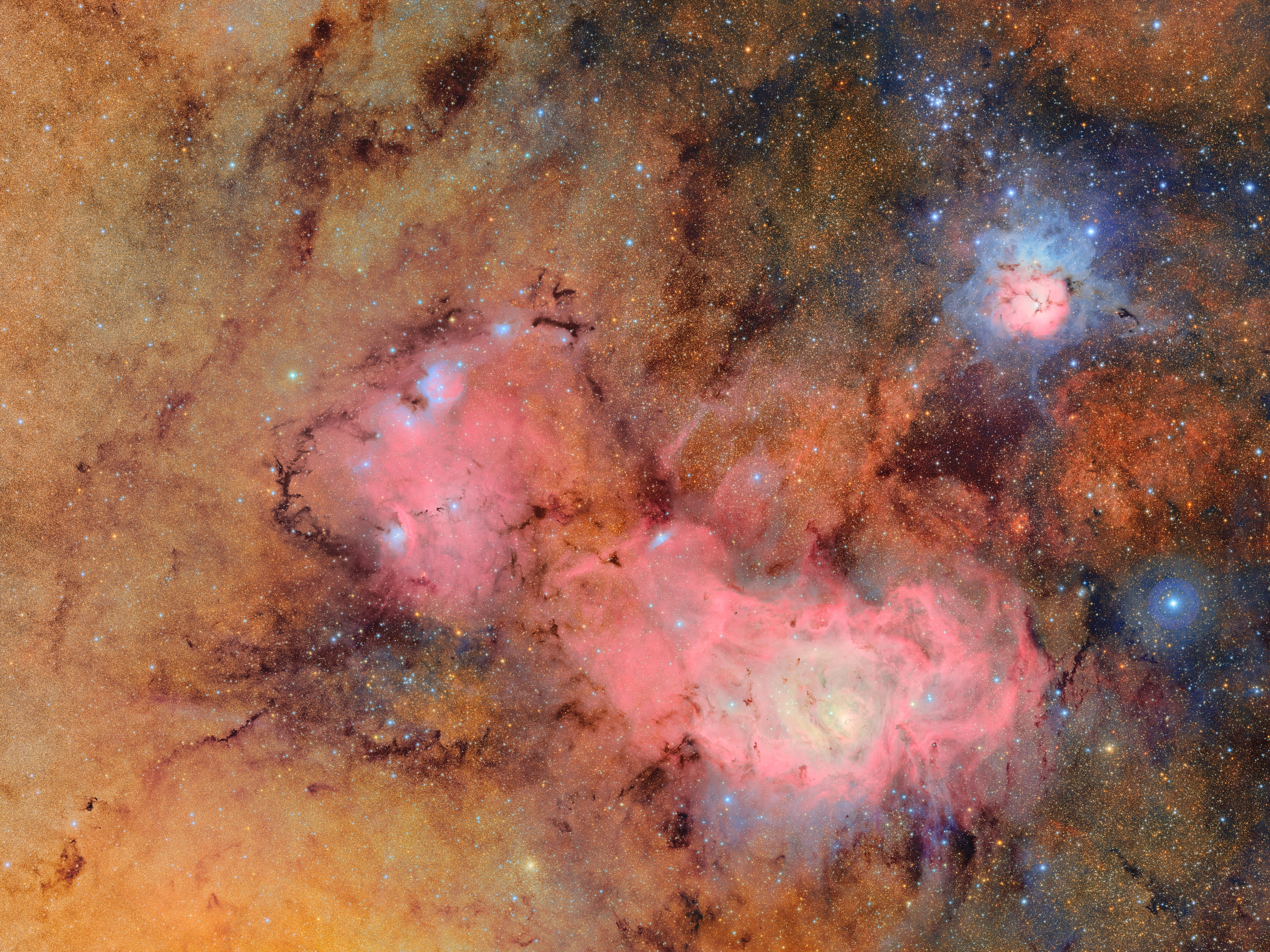 caption: This image combines 678 separate images taken by NSF-DOE Vera C. Rubin Observatory in just over seven hours of observing time. Combining many images in this way clearly reveals otherwise faint or invisible details, such as the clouds of gas and dust that comprise the Trifid nebula (top right) and the Lagoon nebula, which are several thousand light-years away from Earth.