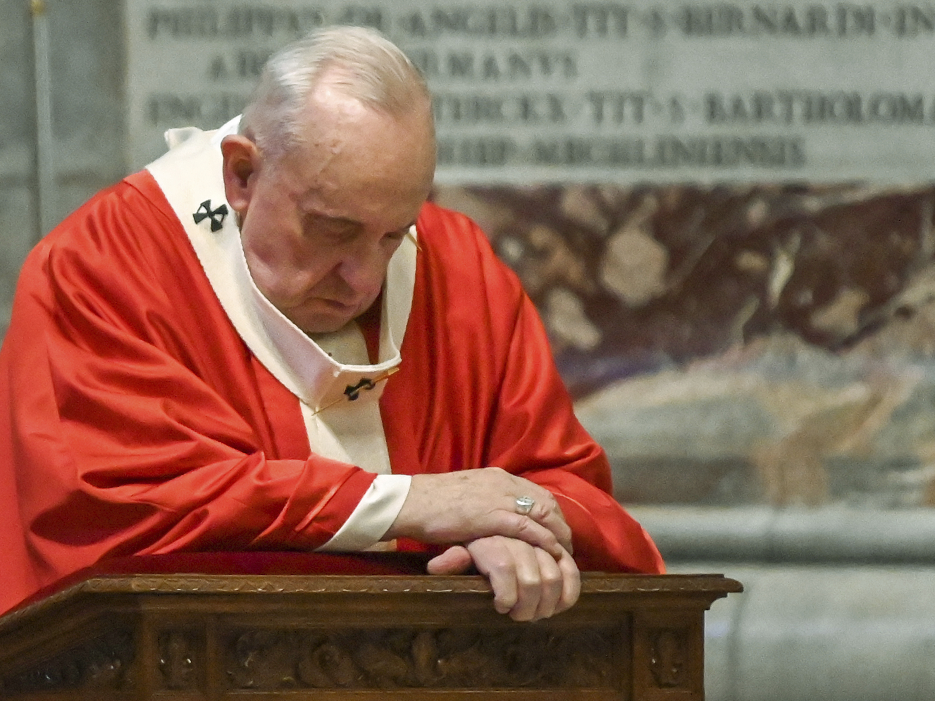 caption: Pope Francis prays as he celebrates Palm Sunday Mass behind closed doors in St. Peter's Basilica, at the Vatican, Sunday, during the lockdown aimed at curbing the spread of coronavirus.