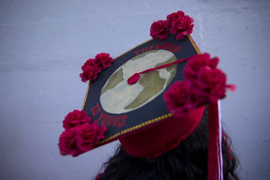 caption: "The world is yours" reads Cleveland Stem High School senior Fana Amanuel's cap ahead of the in-person commencement ceremony on Tuesday, June 15, 2021, at Memorial Stadium in Seattle. 