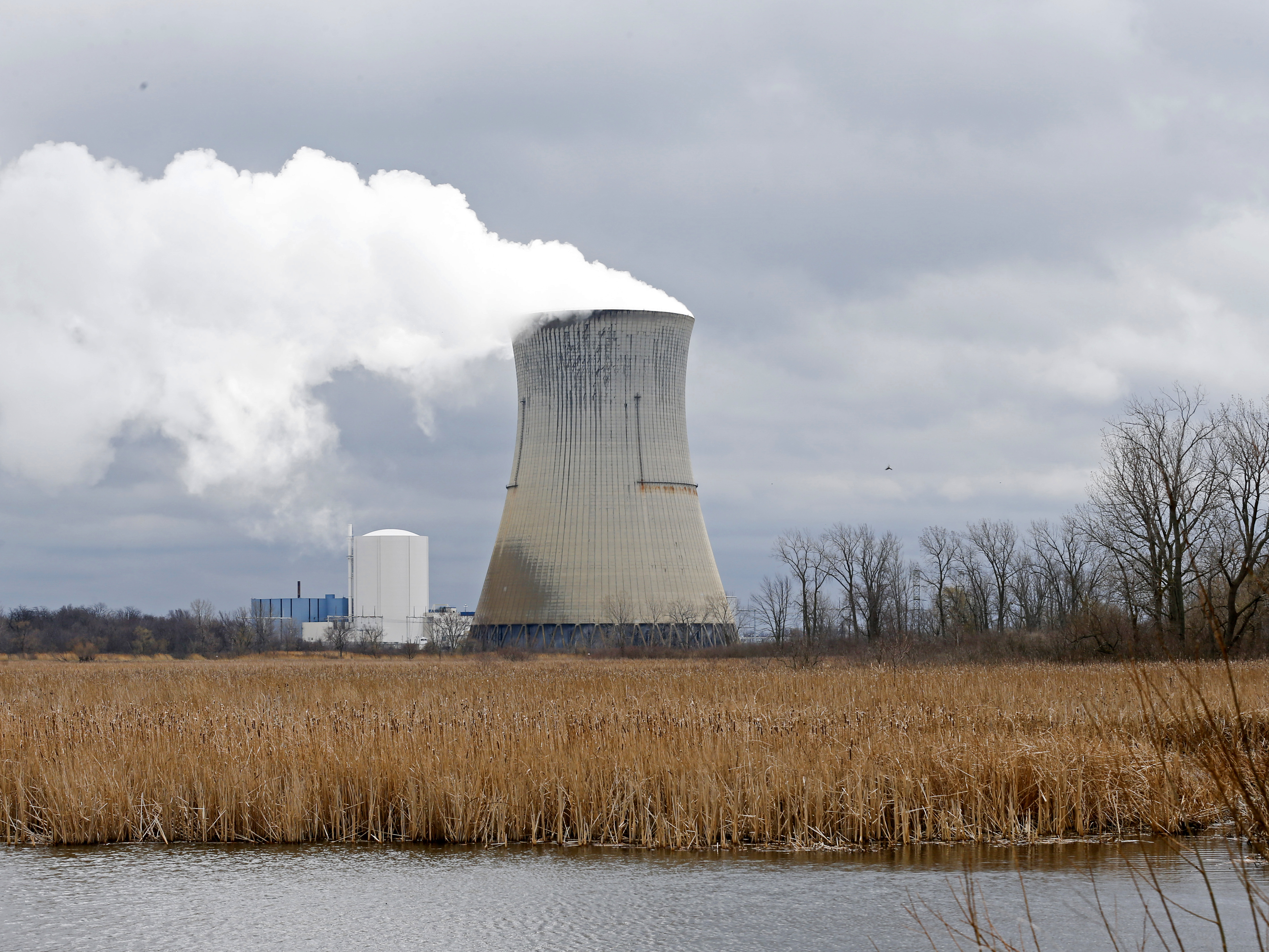 caption: In this April 4, 2017, file photo, plumes of steam drift from the cooling tower of FirstEnergy Corp.'s Davis-Besse Nuclear Power Station in Oak Harbor, Ohio.
