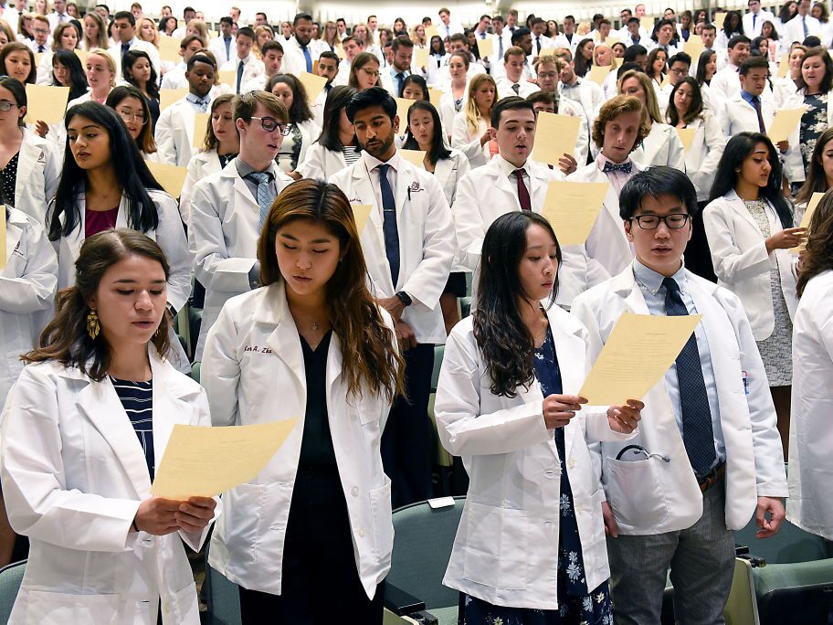 caption: Incoming medical students from the Class of 2023 recite the Hippocratic Oath during the White Coat Ceremony at Albany Medical College on Tuesday, Aug. 6, 2019 in Albany, N.Y.