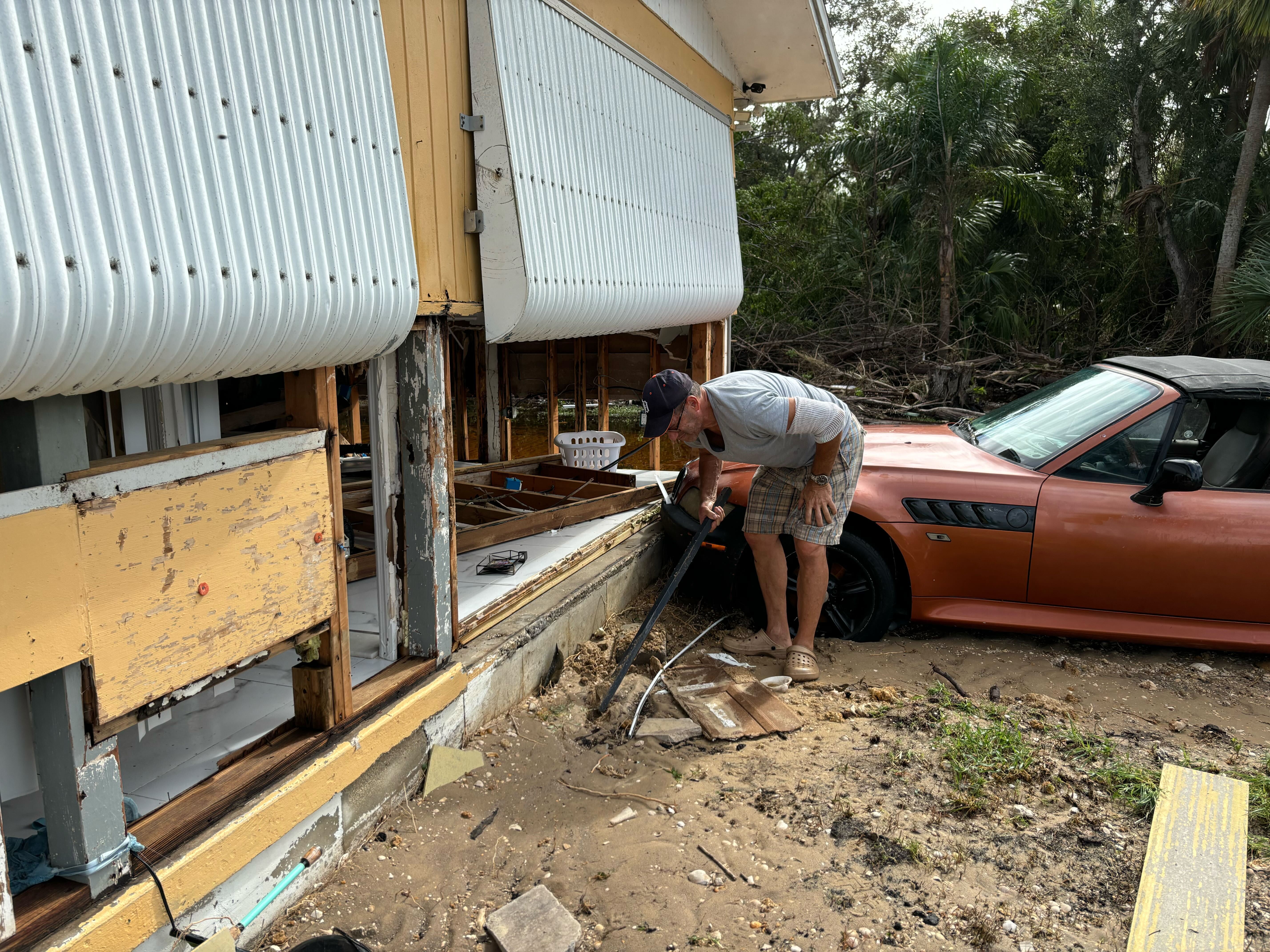 caption: Rick Conflitti surveys the damage at his home in Charlotte Harbor, Fla., on Thursday, hours after Hurricane Milton made landfall nearly 50 miles north.