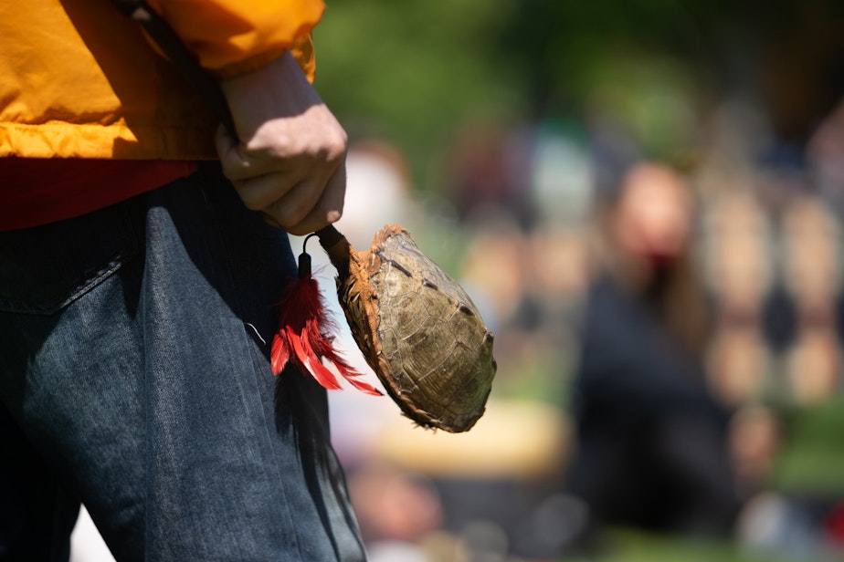 caption: A person holds a rattle shaker made out of turtle shell on Saturday, May 22, 2021, at Seattle Center. 