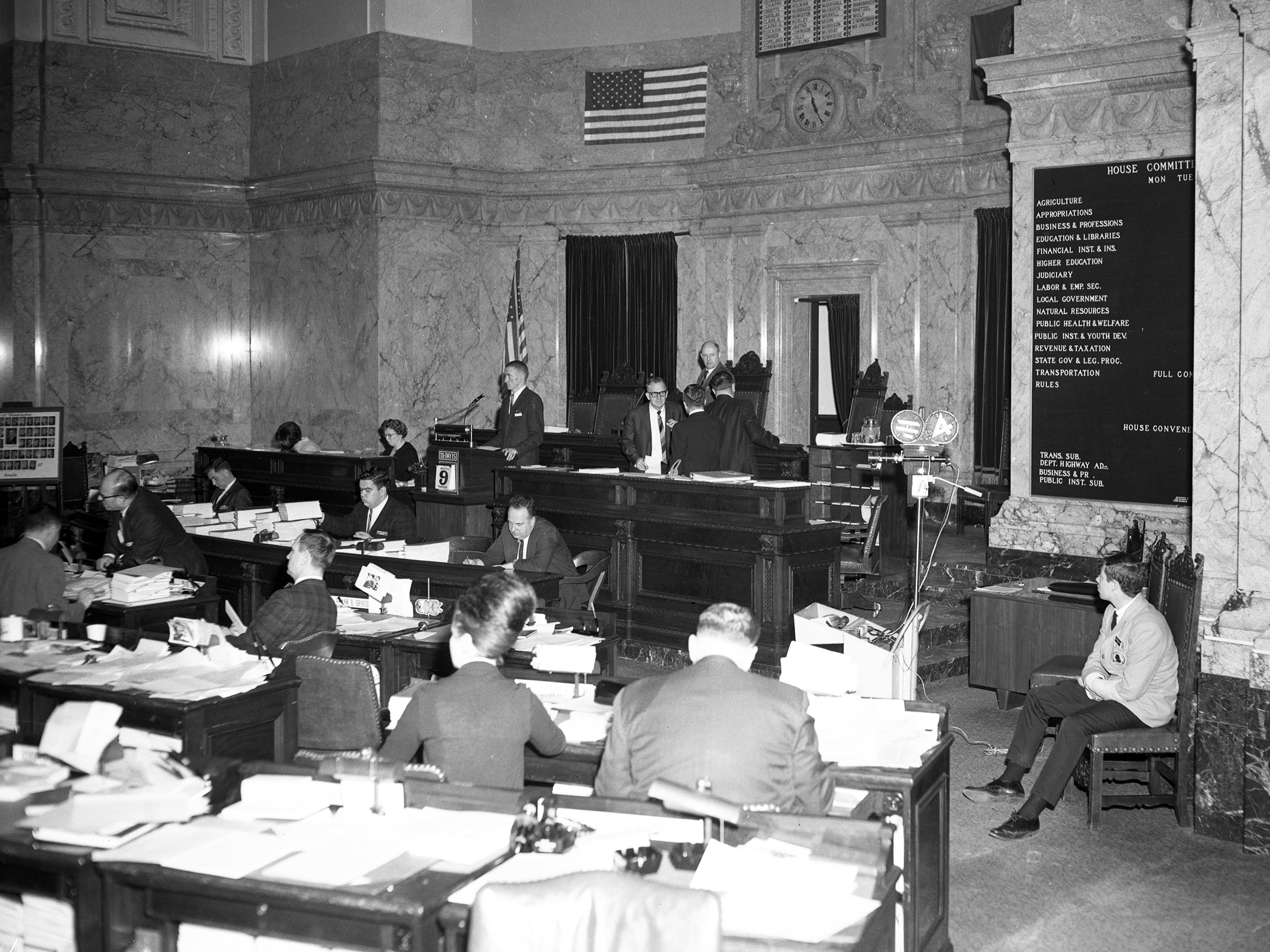 caption: Ralph Munro testifying about the Budd Inlet capture in the legislative building in Olympia, before the House of Representatives. March 9, 1976