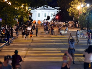 caption: Protesters gather on Friday night at Black Lives Matter Plaza in front of the White House and the statue of former President Andrew Jackson, which is protected by a fence and concrete blocks.