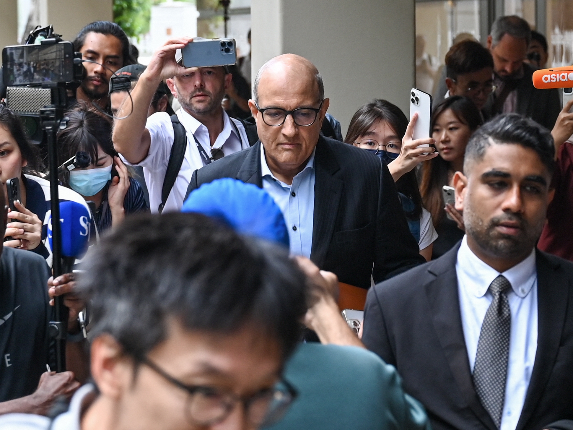 caption: Singapore's former Minister for Transport and Minister-in-charge for Trade Relations S. Iswaran (C) leaves the Supreme Court in Singapore on Thursday.