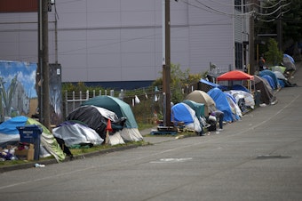caption: Tents line South Weller Street near the intersection of 12th Avenue South on Tuesday, May 19, 2020, in Seattle.