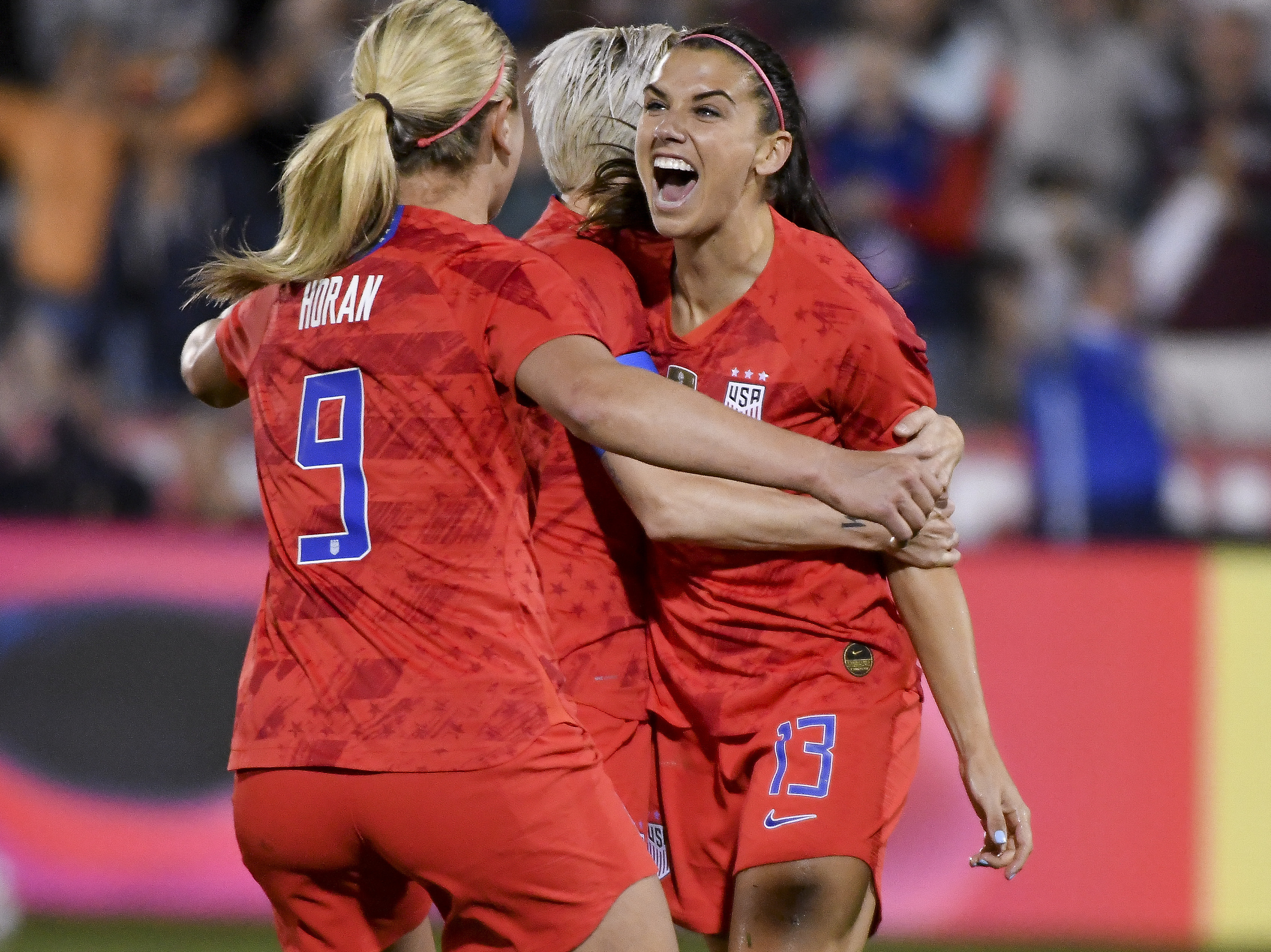 caption: Alex Morgan, right, celebrates with Lindsey Horan and Megan Rapinoe after scoring her 100th international goal on April 4 in Colorado. The three will represent the U.S. at the Women's World Cup next month in France.