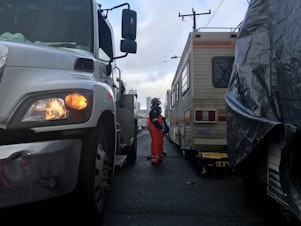 caption: As RV Wastewater Pilot Program coordinator for Seattle Public Utilities, Chris Wilkerson visits people living in motor homes and trailers and offers to pump out their waste for free.