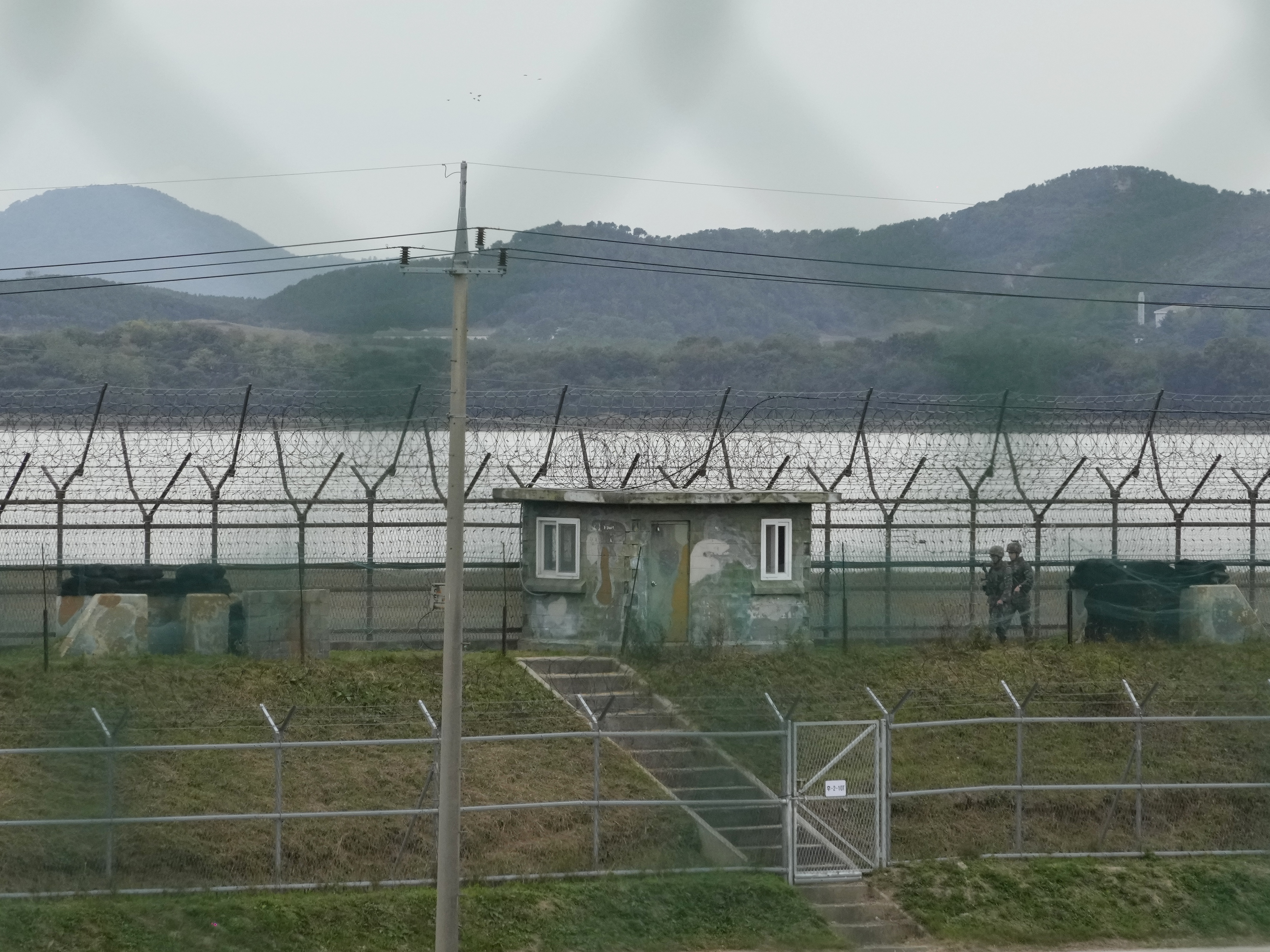 caption: South Korean army soldiers patrol along the barbed-wire fence in Paju, South Korea, near the border with North Korea, Monday.
