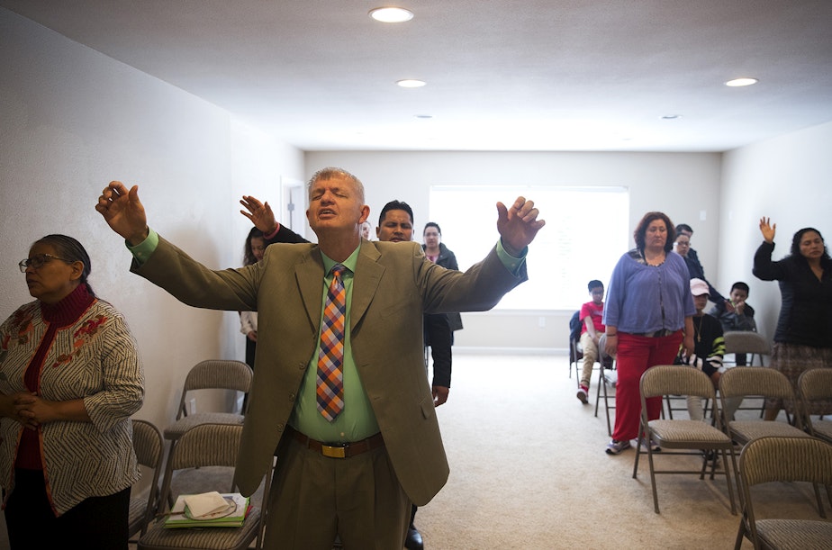 caption: Nathan Roberts, center, during a church service in the basement of his home on Sunday, September 16, 2018, in Des Moines.