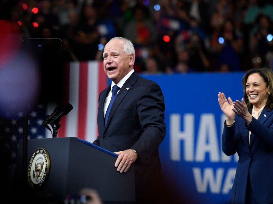 caption: Vice President and Democratic presidential nominee Kamala Harris applauds as her running mate, Minnesota Gov. Tim Walz, speaks at Temple University's Liacouras Center in Philadelphia on Tuesday. 