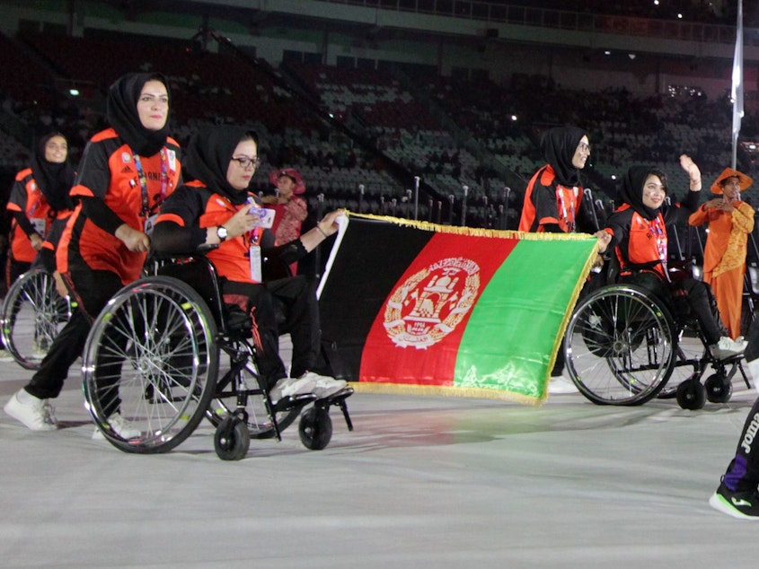 caption: The Afghanistan Paralympic team won't compete in the Tokyo Paralympics, with commercial air travel halted due to the Taliban's sudden takeover. Here, the country's athletes are seen at the opening ceremony of the 2018 Asian Para Games at the Gelora Bung Karno main stadium in Jakarta.