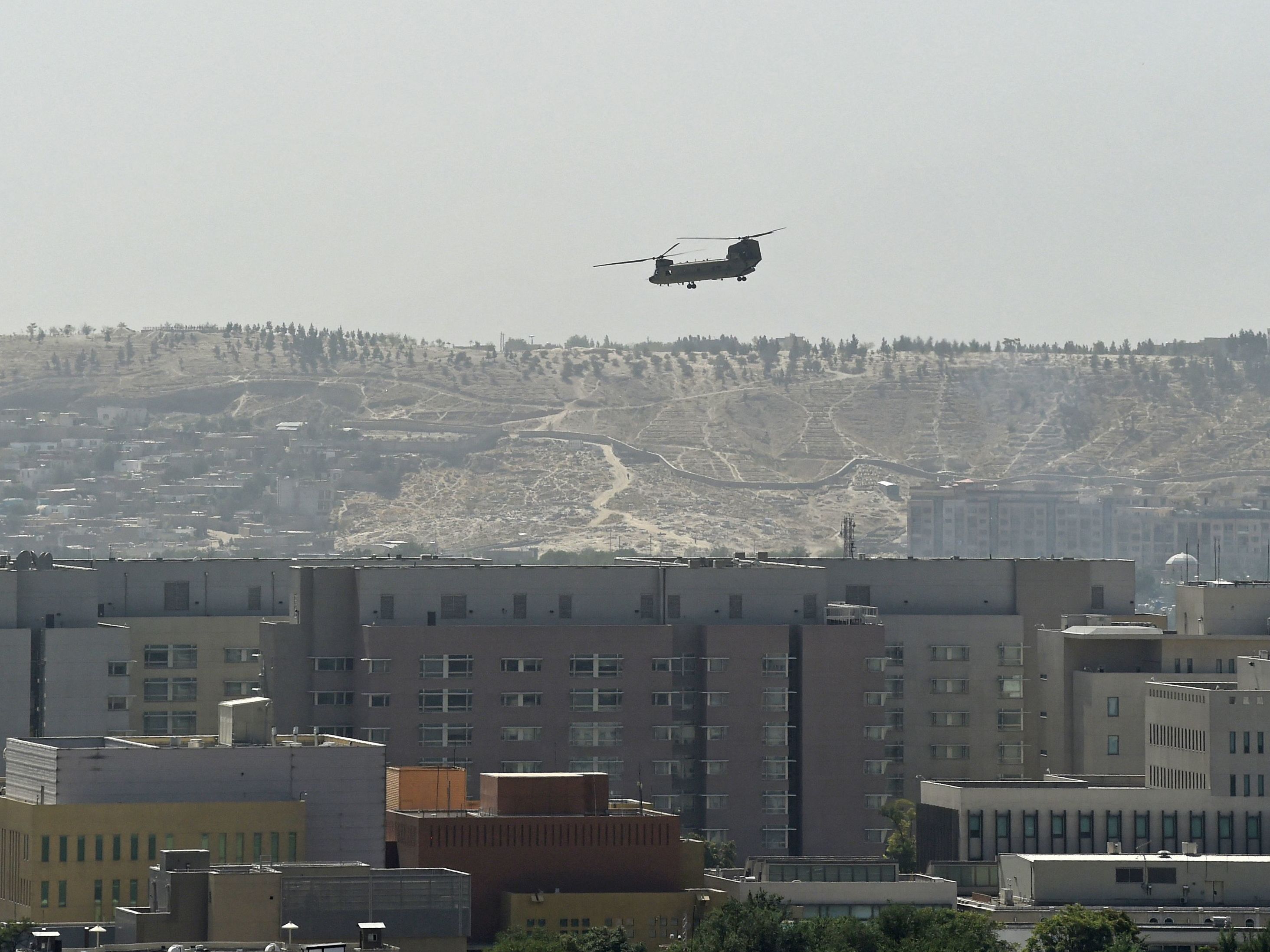 caption: A U.S. military helicopter is pictured flying above the U.S. Embassy in Kabul on Sunday. The Taliban swept into Kabul, facing little resistance.