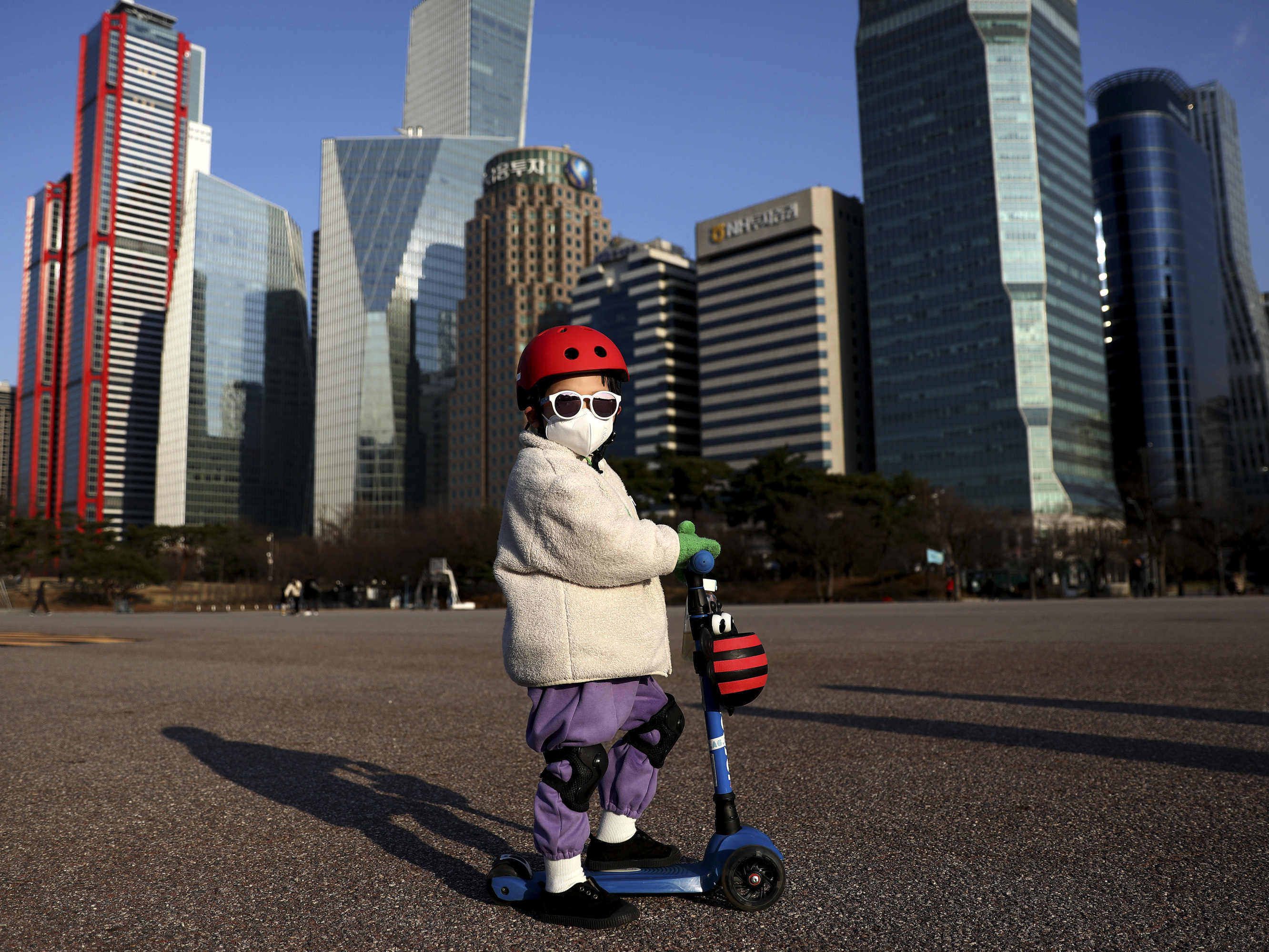 caption: A South Korean child masks up to ride a scooter on Feb. 27, 2020 in Seoul.