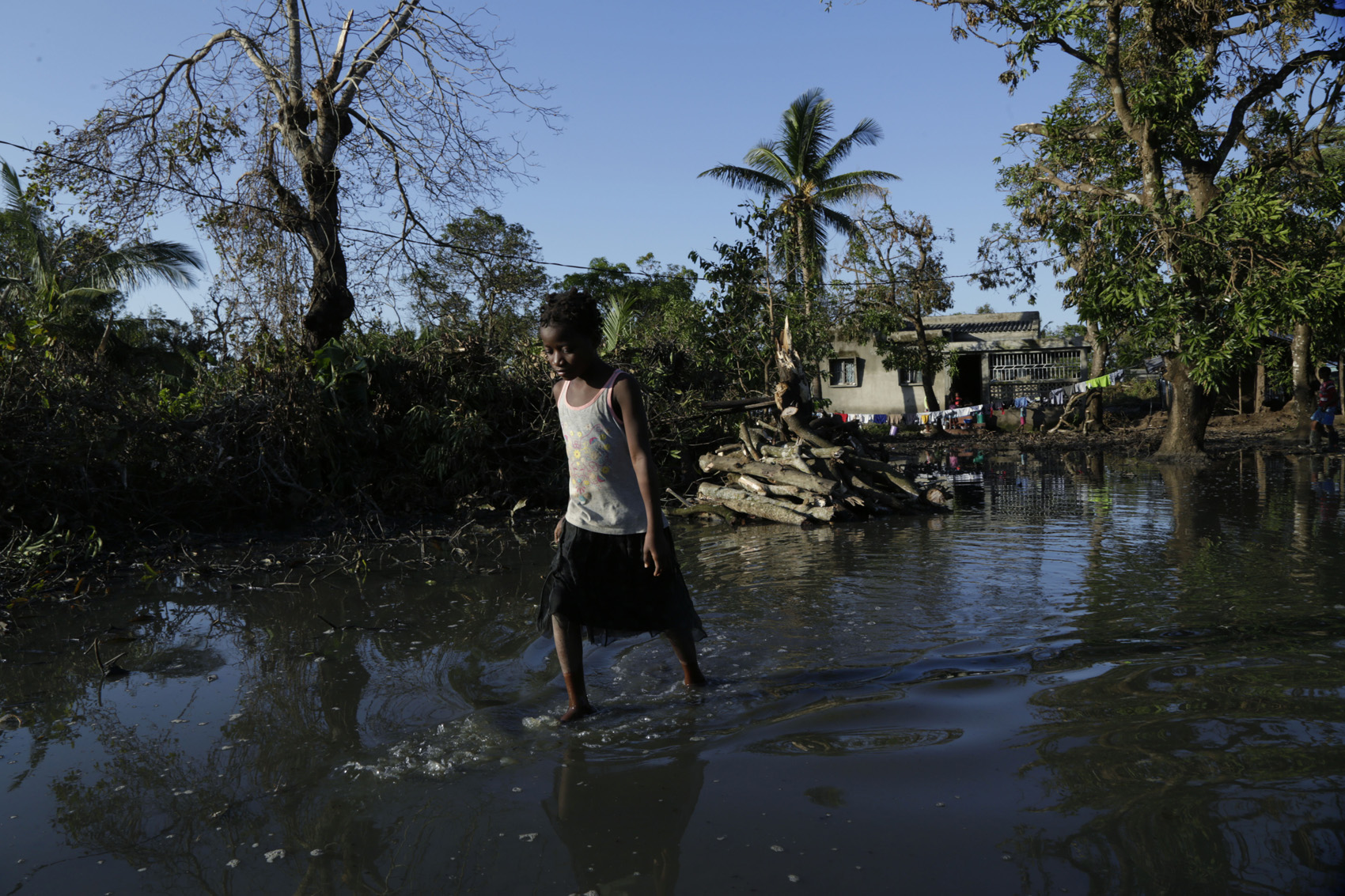 caption: A young girl walks in the water at Mafambisse, about 60km outside of Beira, Mozambique, Tuesday, March 26, 2019. (Themba Hadebe/AP)