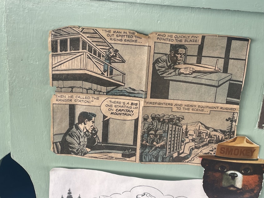 caption: A photo of a comic strip that shows a fire lookout at work. Little art pieces like this decorate the inside of the fire lookout. 