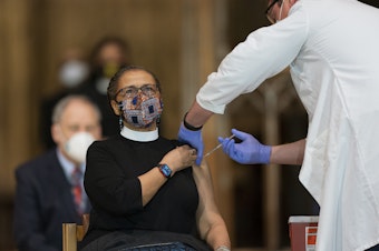 caption: A pastor is administered with the Johnson & Johnson COVID-19 vaccine in May, during a gathering of a group of interfaith clergy members, community leaders and officials at the Washington National Cathedral, to encourage faith communities to get the COVID vaccine.