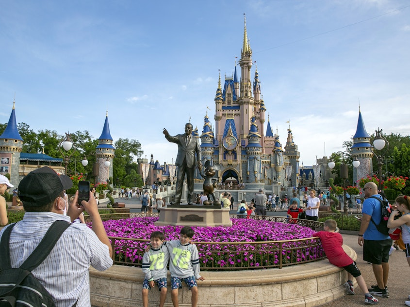 caption: People visit the Magic Kingdom Park at Walt Disney World Resort in Lake Buena Vista, Fla., April 18, 2022.